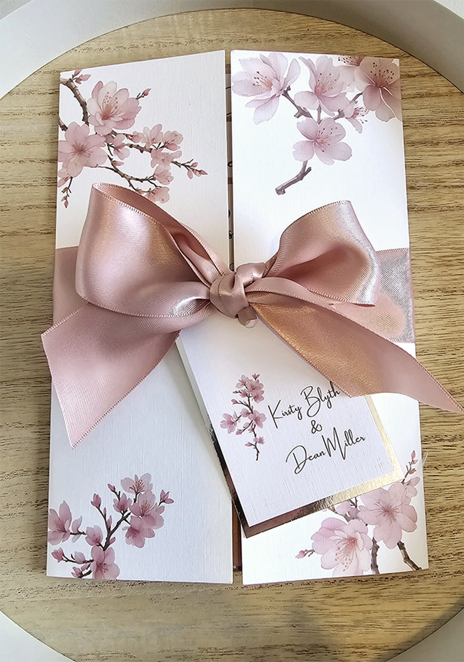 Cherry blossom themed invite with dusky pink bow wrapped around